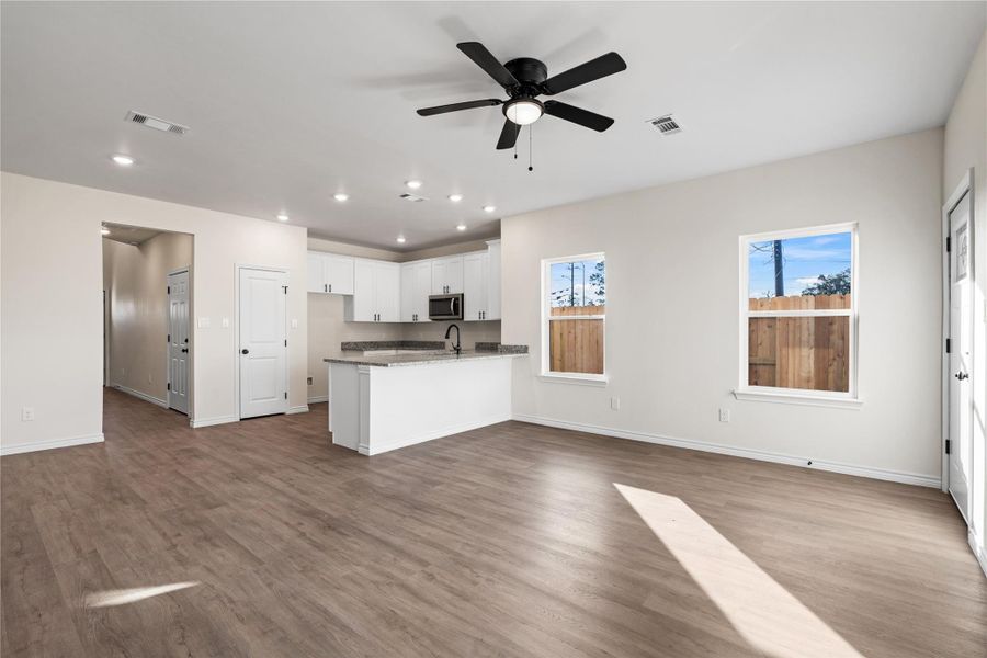 The seamless flow from kitchen to living room creates a welcoming atmosphere, perfect for gathering, relaxing, or hosting with ease.