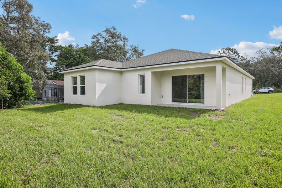 Elegant stucco exterior and expansive lawn in Spring Hill. Ideal for luxurious outdoor living.