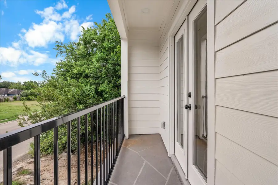 Private balcony off the third bedroom — iron railing, stone tile, and open sky above Private balcony off the third bedroom — iron railing, stone tile, and open sky above