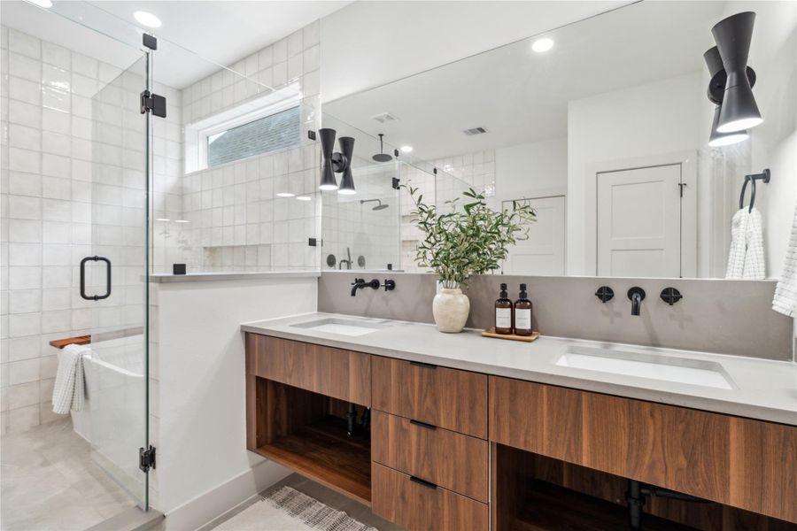 Dual sinks and a sleek floating vanity paired with a full-width mirror make your morning routine feel effortless and elevated. Dual sinks and a sleek floating vanity paired with a full-width mirror make your morning routine feel effortless and elevated.