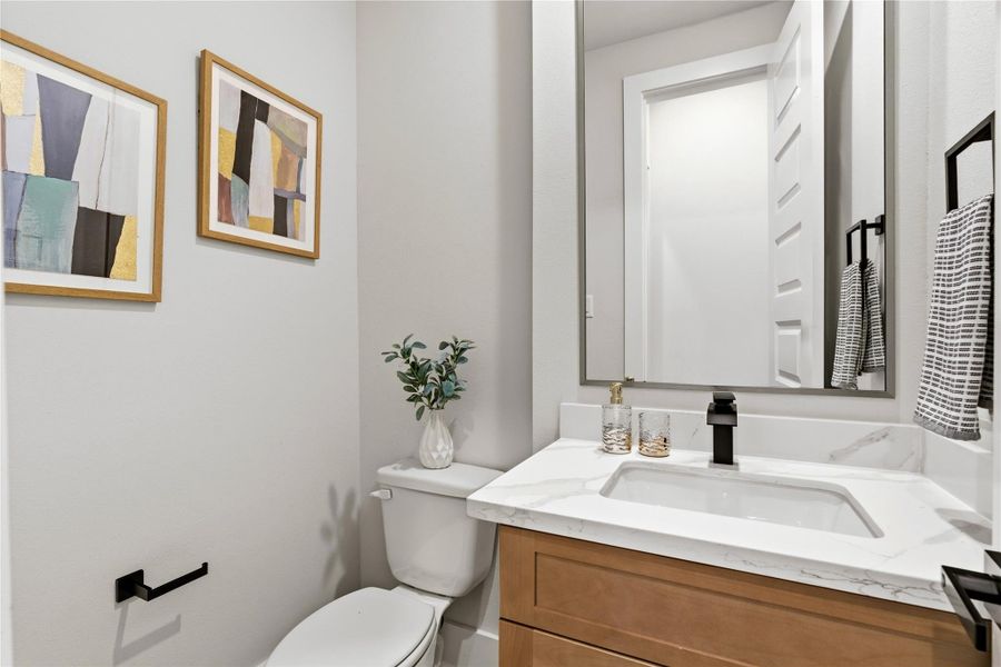 A clean, modern powder room defined by streamlined finishes and subtle contrast, offering both functionality and a refined aesthetic. A clean, modern powder room defined by streamlined finishes and subtle contrast, offering both functionality and a refined aesthetic.