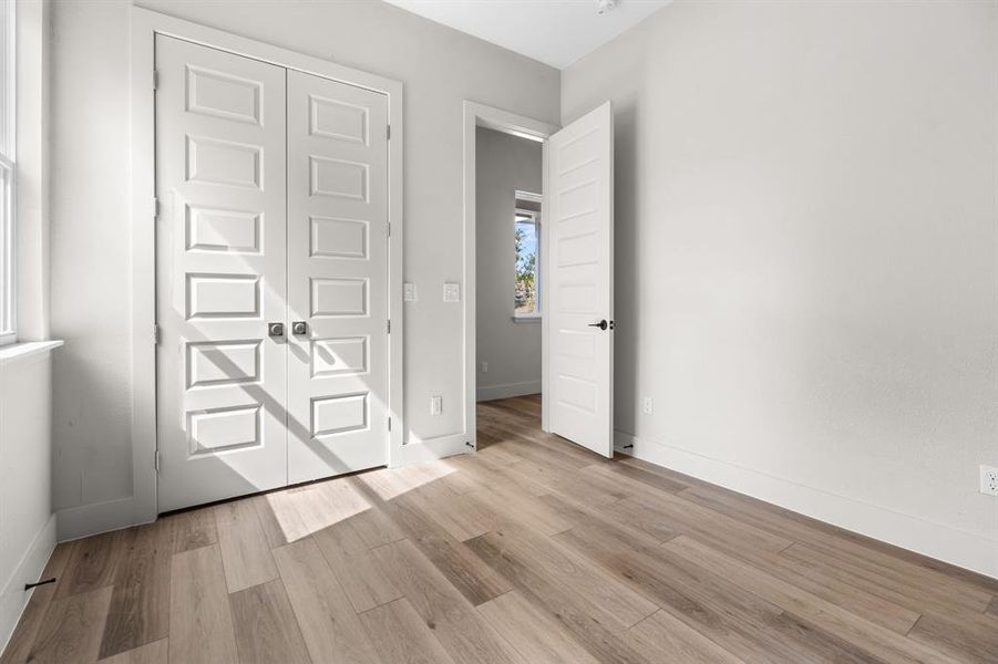 Unfurnished bedroom featuring light wood-type flooring and a closet