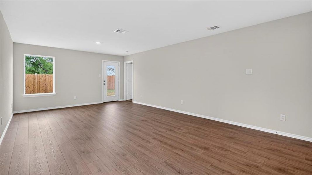 Spacious interior featuring wood-finish flooring, light grey walls, and white trim