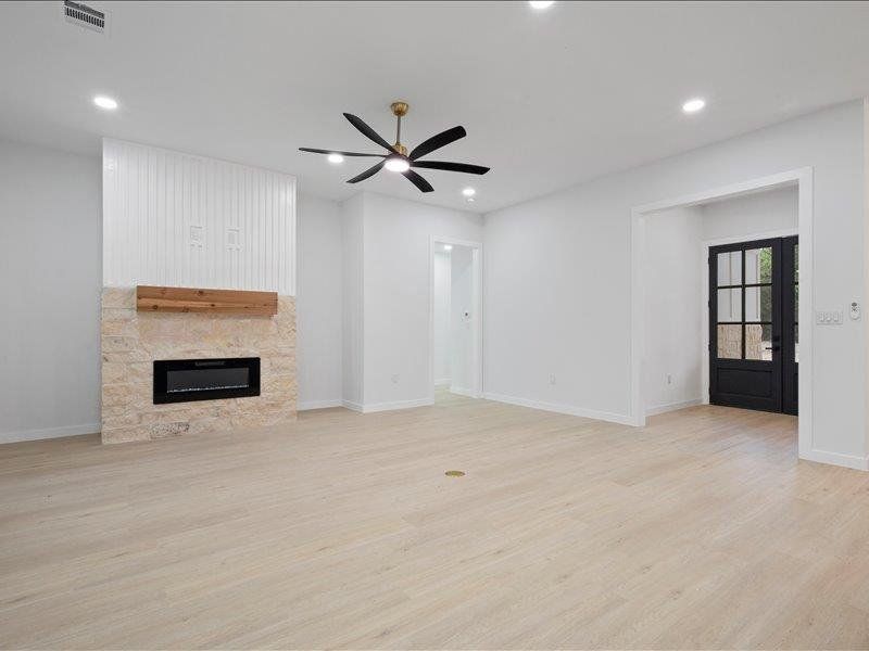 Spacious interior featuring light-toned flooring, recessed lighting, and a contemporary ceiling fan