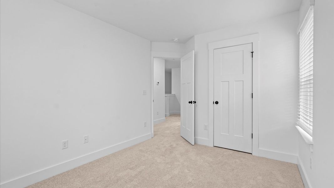 Superior comfort in a secondary bedroom with plush carpet and an oversized walk-in closet Superior comfort in a secondary bedroom with plush carpet and an oversized walk-in closet