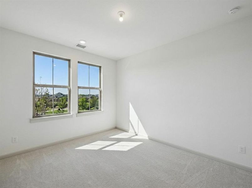 Bright room featuring two large windows, neutral carpeting, white walls, and a recessed ceiling light