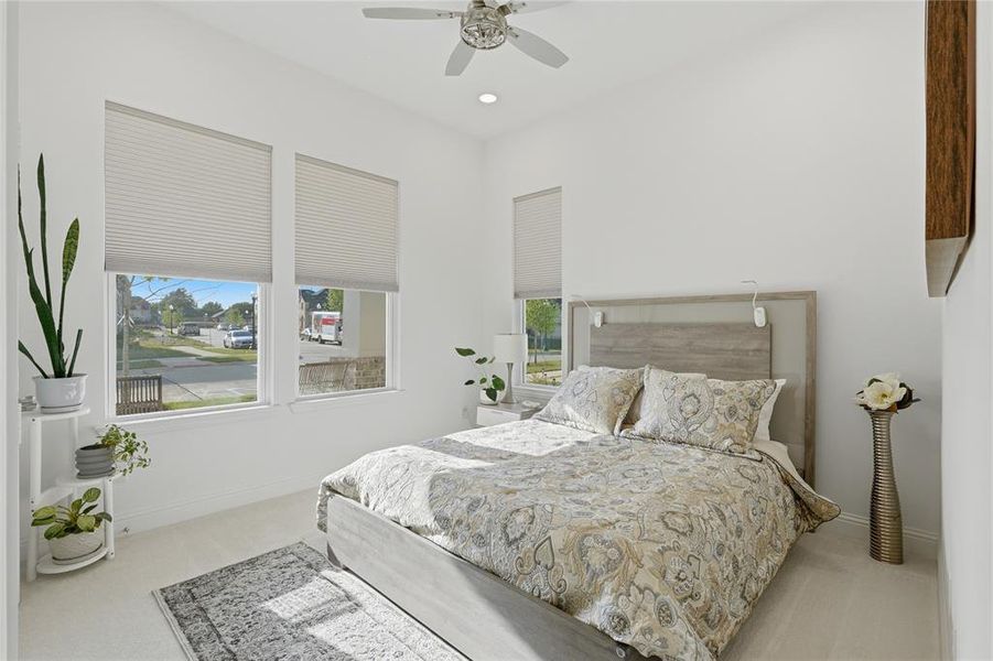 Bright room featuring three windows with cellular blinds, a ceiling fan with integrated lighting, and recessed ceiling lights Bright room featuring three windows with cellular blinds, a ceiling fan with integrated lighting, and recessed ceiling lights