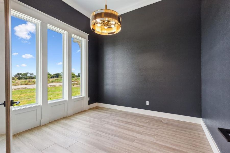 Spare room with a notable chandelier and light hardwood / wood-style flooring