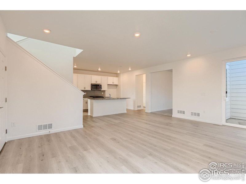 Living room flowing into the kitchen. Leads to the office and the side patio.