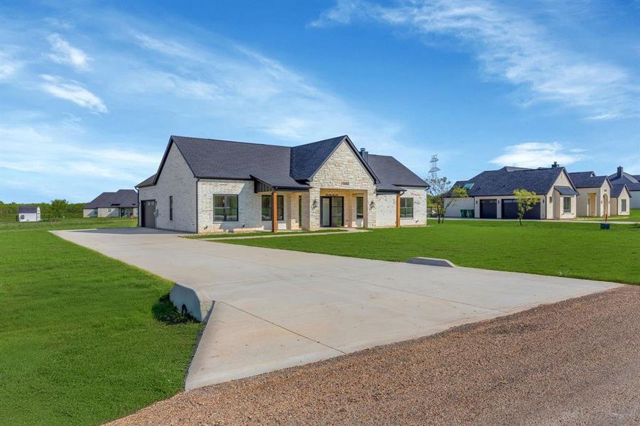 Oversized concrete drive leading up to 2 car garage with 8' tall garage door.