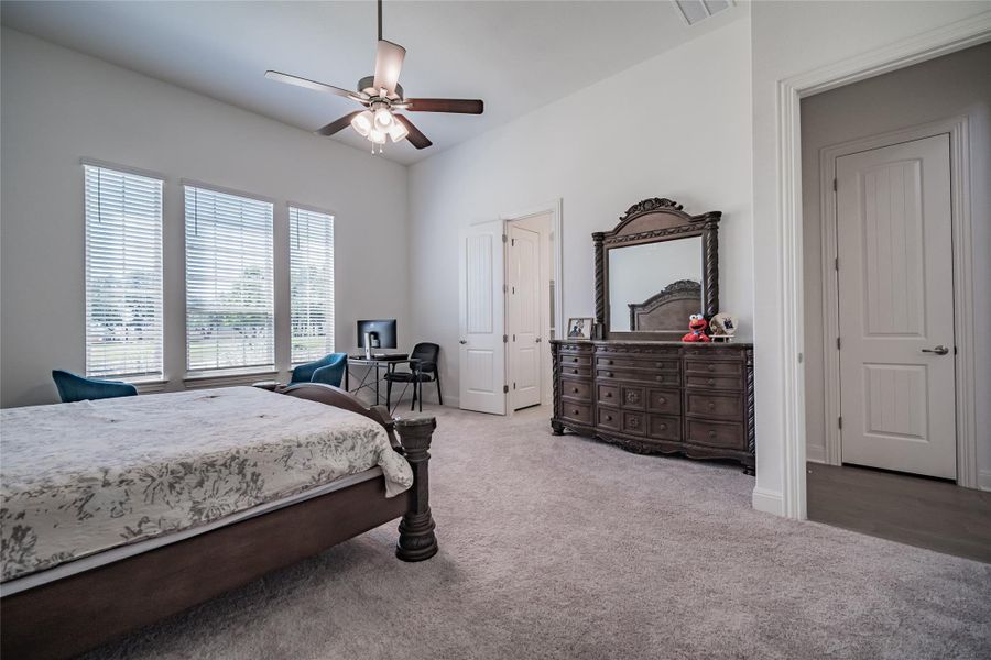 A spacious bedroom provides a restful retreat with multiple windows offering natural light.