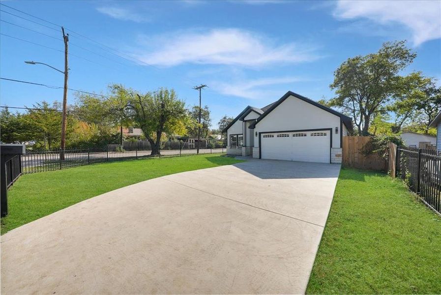 View of front facade featuring driveway, stucco siding, a garage, and stone siding