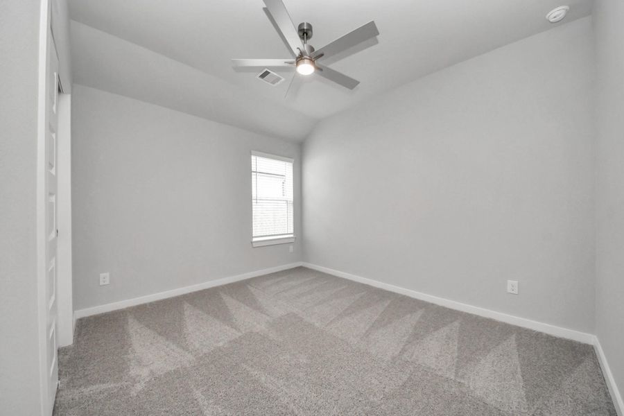Secondary bedroom features plush carpeting, large windows that let in plenty of natural light, bright paint, and spacious closets.