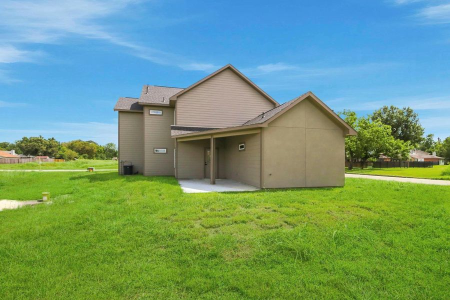 Spacious two-story home with a modern exterior and expansive green lawn, situated in a serene neighborhood.