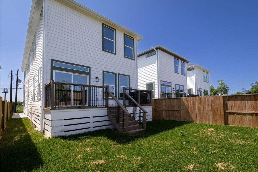 Spacious backyard with fresh green grass and a modern deck, perfect for outdoor entertaining. Spacious backyard with fresh green grass and a modern deck, perfect for outdoor entertaining.