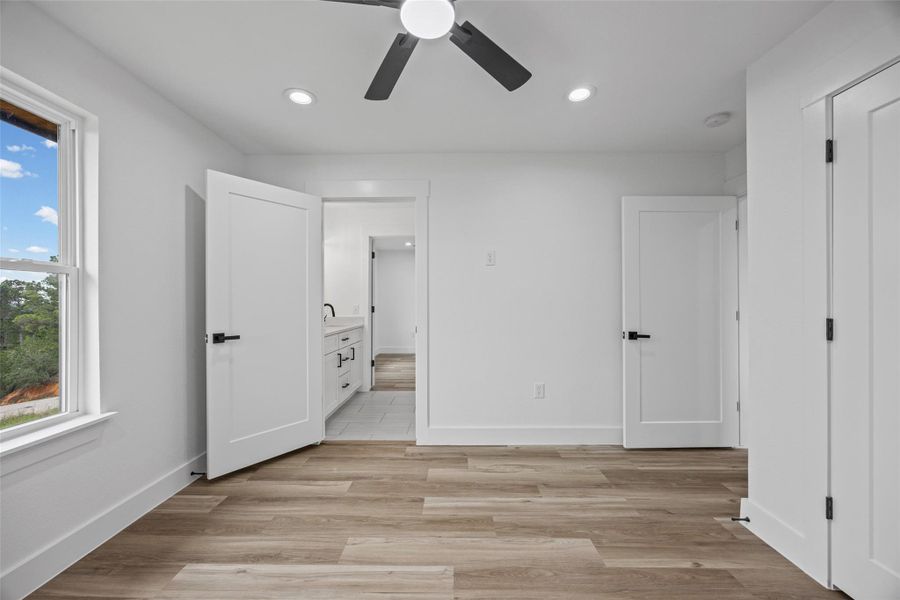 Bright room featuring wood-finish flooring, recessed lighting, and a contemporary ceiling fan Bright room featuring wood-finish flooring, recessed lighting, and a contemporary ceiling fan