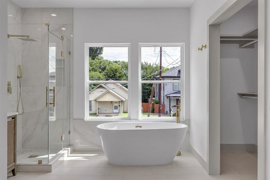 Full bath with plenty of natural light, a marble finish shower, and a freestanding tub Full bath with plenty of natural light, a marble finish shower, and a freestanding tub