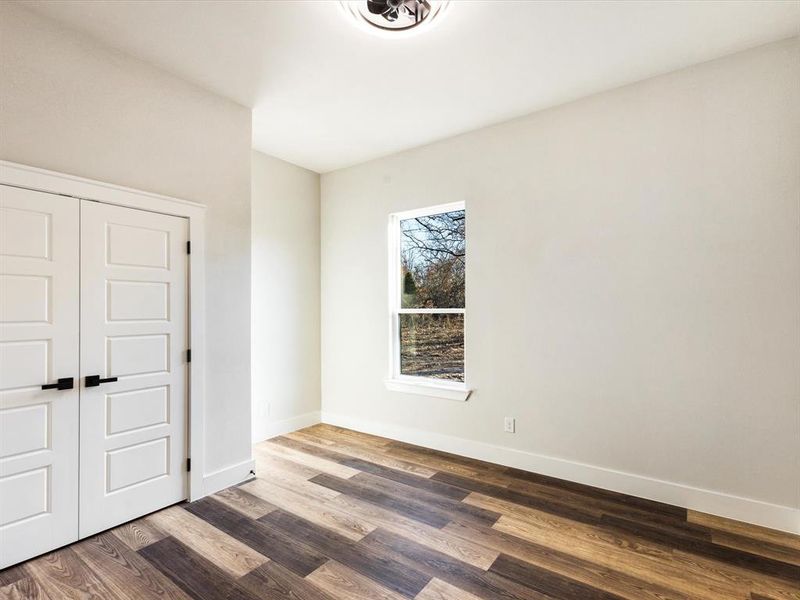 Unfurnished bedroom featuring a closet and wood finished floors Unfurnished bedroom featuring a closet and wood finished floors