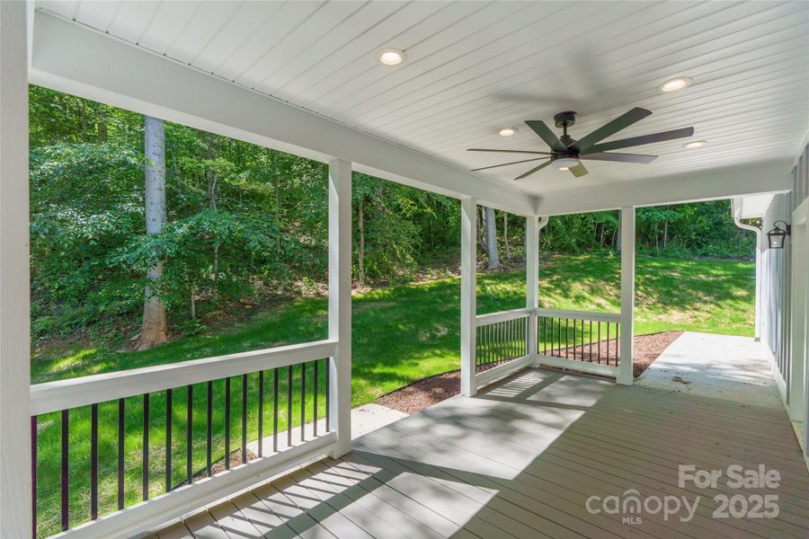 Rear covered porch with lighted path leading to exterior garage door