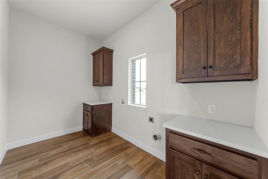 Laundry area featuring hookup for an electric dryer, cabinets, and washer hookup