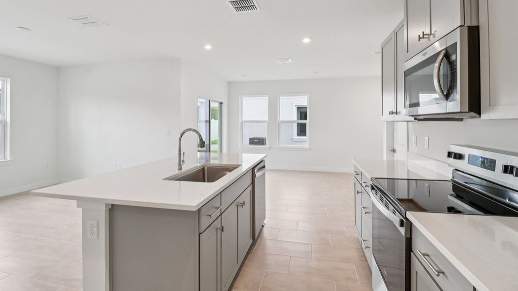 Kitchen and Living Room in the Monterey End Townhome by DRB Homes - Cyrene at Harmony in St Cloud FL