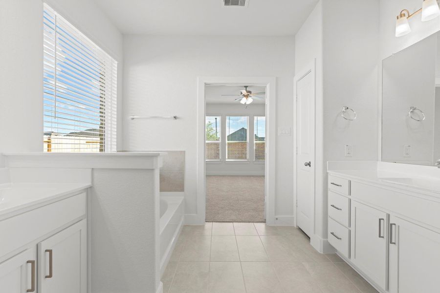 Step into this bright and spacious primary bathroom featuring clean tile flooring, a relaxing soaking tub, and a clear view into the primary suite. The generous layout, natural light, and fresh finishes create a calm, spa-like atmosphere you’ll enjoy every day. Step into this bright and spacious primary bathroom featuring clean tile flooring, a relaxing soaking tub, and a clear view into the primary suite. The generous layout, natural light, and fresh finishes create a calm, spa-like atmosphere you’ll enjoy every day.
