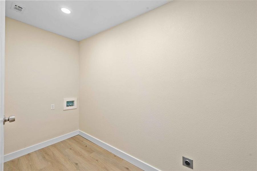 Washroom featuring light wood finished floors, hookup for an electric dryer, recessed lighting, and hookup for a washing machine Washroom featuring light wood finished floors, hookup for an electric dryer, recessed lighting, and hookup for a washing machine