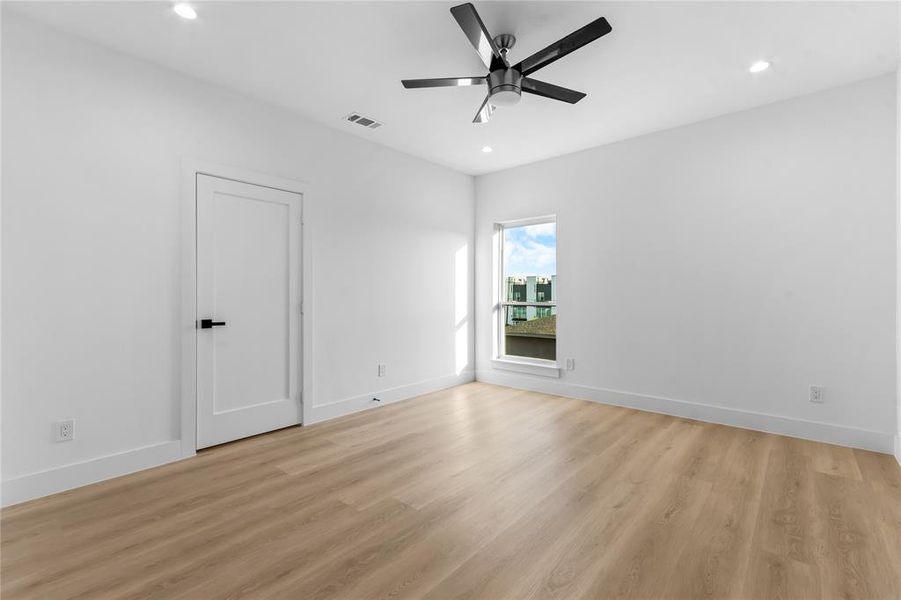 Spacious room featuring wood-finish flooring, recessed lighting, and a contemporary ceiling fan Spacious room featuring wood-finish flooring, recessed lighting, and a contemporary ceiling fan