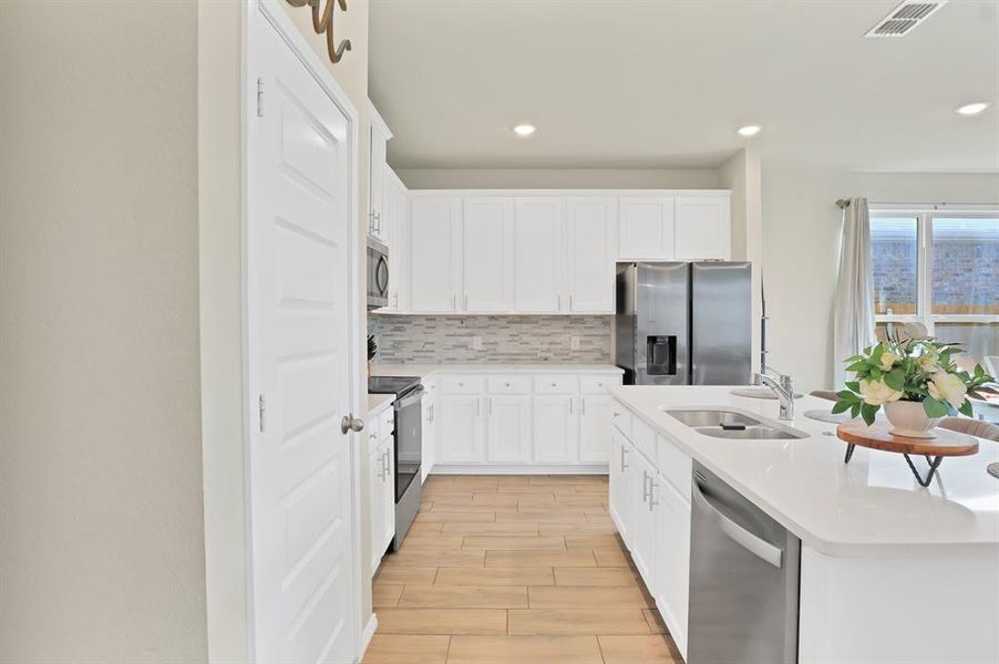 Kitchen featuring sink, white cabinets, stainless steel appliances, and light hardwood / wood-style floors