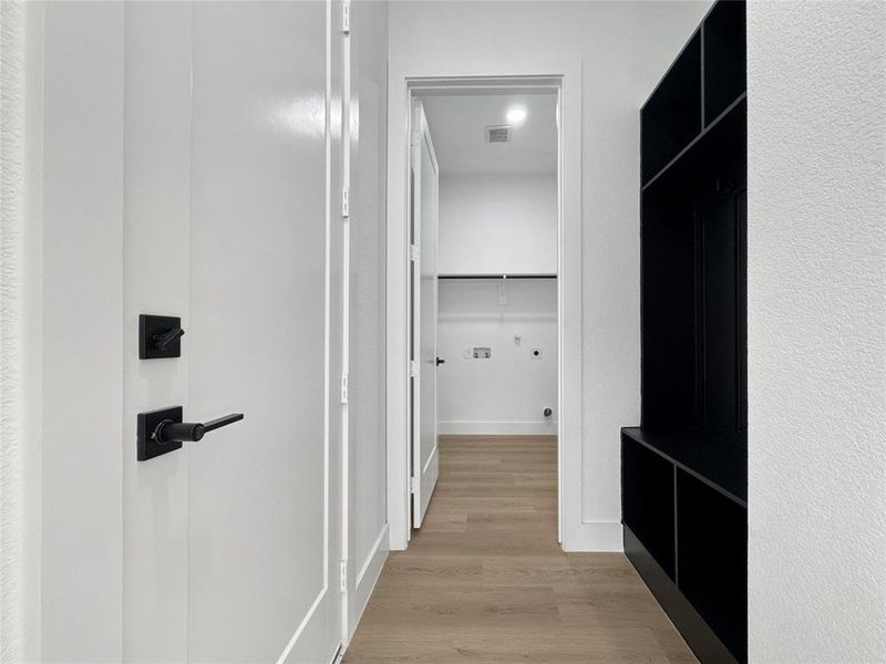 Hallway featuring light wood-style flooring and baseboards