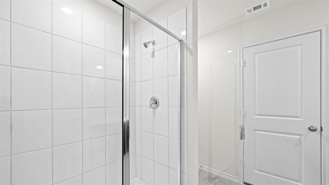 Spacious walk-in shower featuring white square tile surround, clear glass enclosure, and chrome fixtures