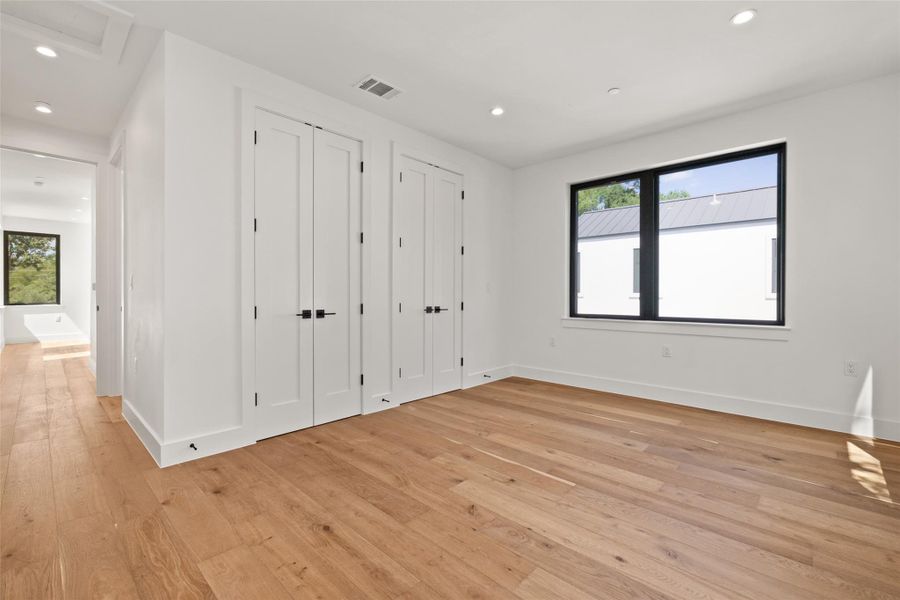 Unfurnished bedroom featuring two closets, light wood finished floors, and recessed lighting