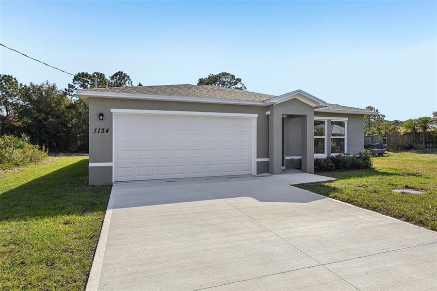 Front exterior of a new home in Palm Bay Classic, Palm Bay, FL, highlighting curb appeal (Image 2).