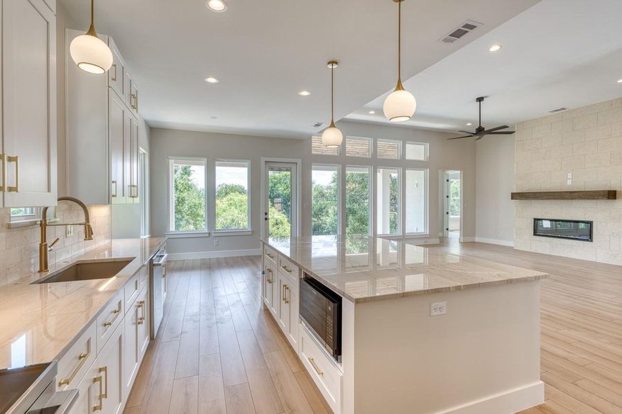 An open concept kitchen features warm wood flooring and ample natural light.