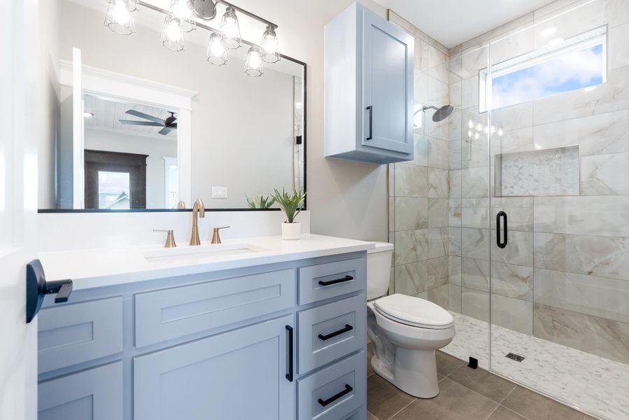 Bathroom featuring vanity, a shower stall, plenty of natural light, and tile patterned floors Bathroom featuring vanity, a shower stall, plenty of natural light, and tile patterned floors