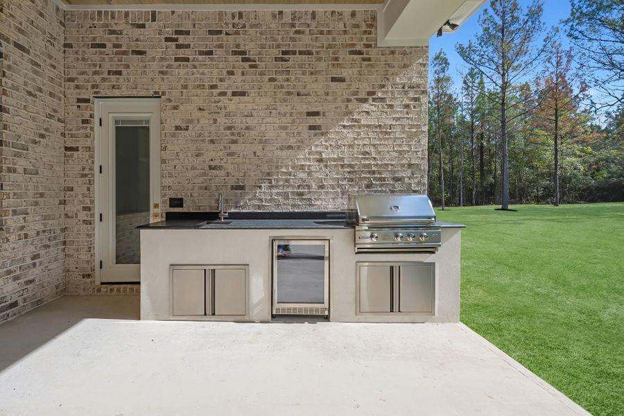 Outdoor kitchen featuring built-in appliances, ample counter space, and a perfect setup for cooking and entertaining in the fresh air. Outdoor kitchen featuring built-in appliances, ample counter space, and a perfect setup for cooking and entertaining in the fresh air.