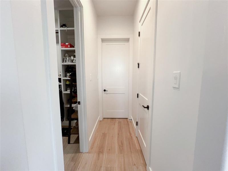 Corridor featuring light wood-style floors and baseboards