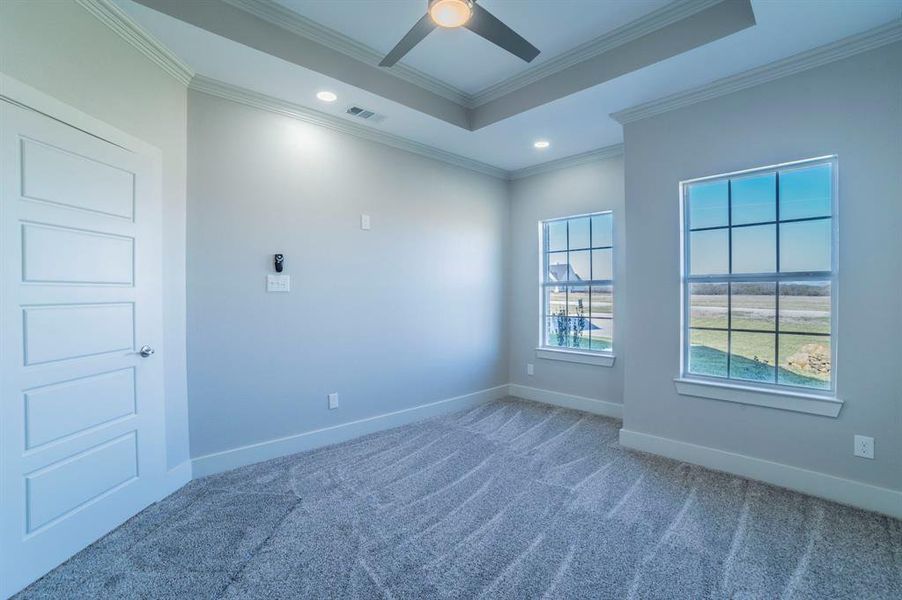 Carpeted empty room featuring recessed lighting, crown molding, a raised ceiling, and ceiling fan