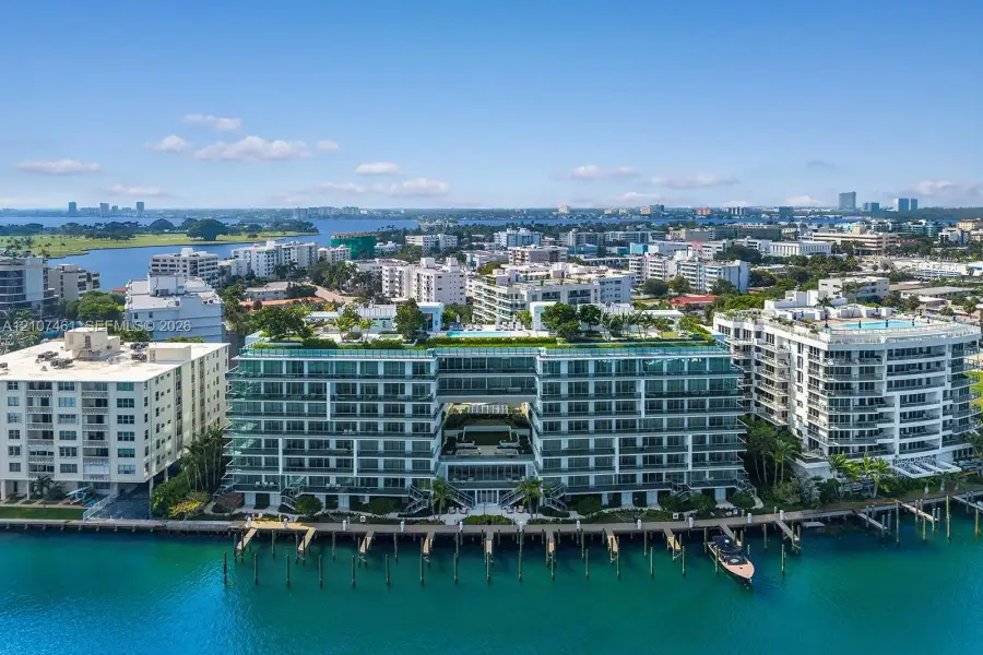 Waterfront mid-rise building featuring a glass-railed rooftop terrace, integrated pool deck, private boat slips, and floor-to-ceiling windows Waterfront mid-rise building featuring a glass-railed rooftop terrace, integrated pool deck, private boat slips, and floor-to-ceiling windows