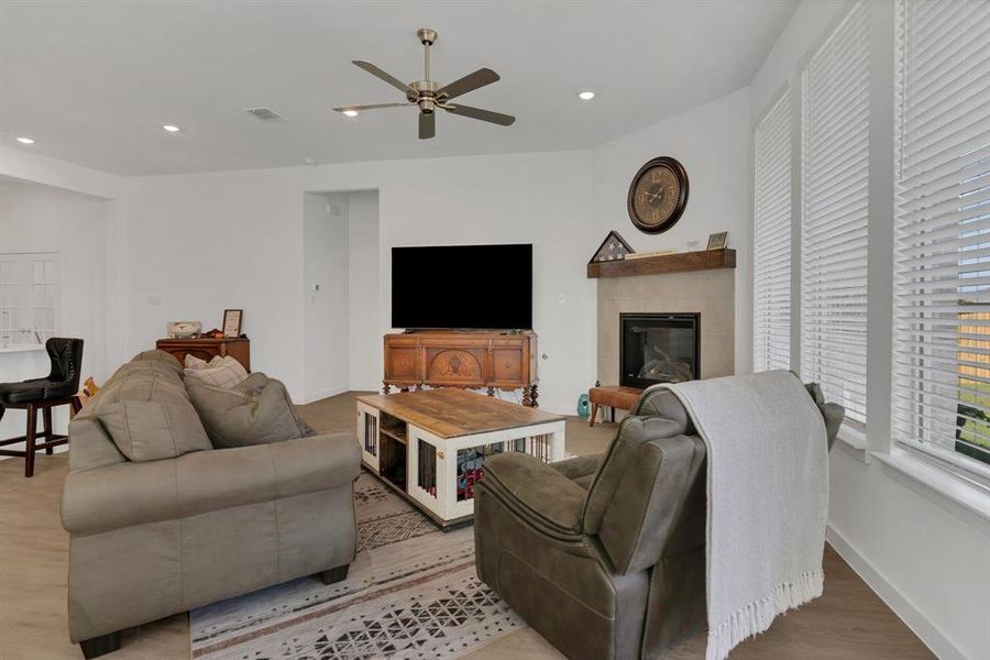 Living room featuring recessed lighting, a tile fireplace, light wood-type flooring, and ceiling fan