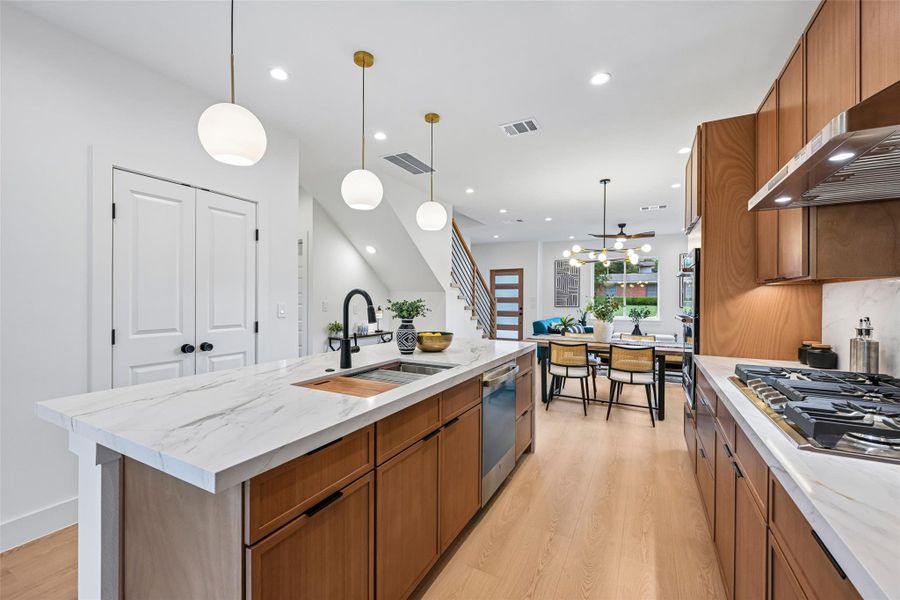 A spacious kitchen island with a built-in sink anchors this luminous open-concept living space.