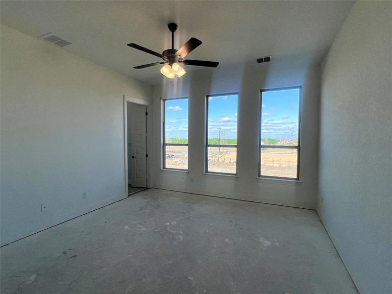 Unfurnished room featuring visible vents, unfinished concrete flooring, and ceiling fan