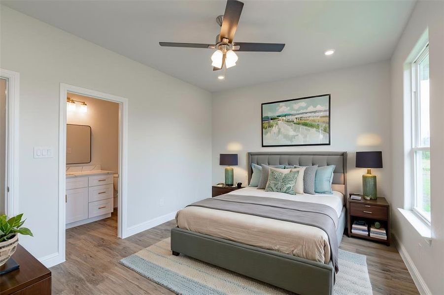 Bedroom featuring light hardwood / wood-style flooring, ensuite bathroom, and ceiling fan