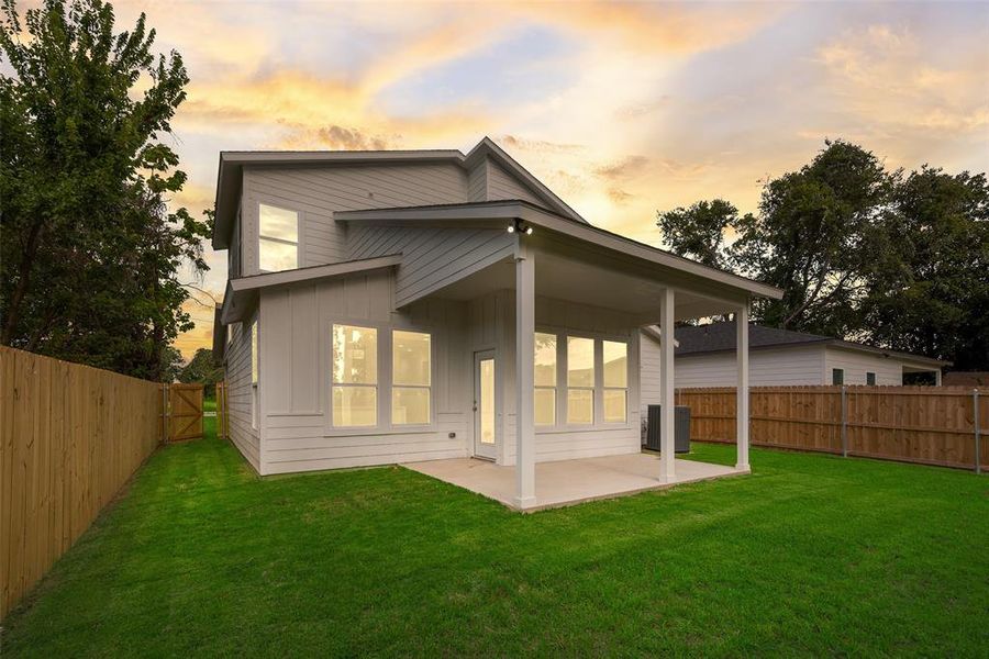 Back of house at dusk with a fenced backyard, a patio, and board and batten siding Back of house at dusk with a fenced backyard, a patio, and board and batten siding