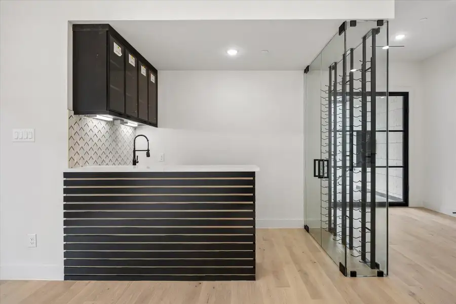 Glass walls enclose the wine storage area.