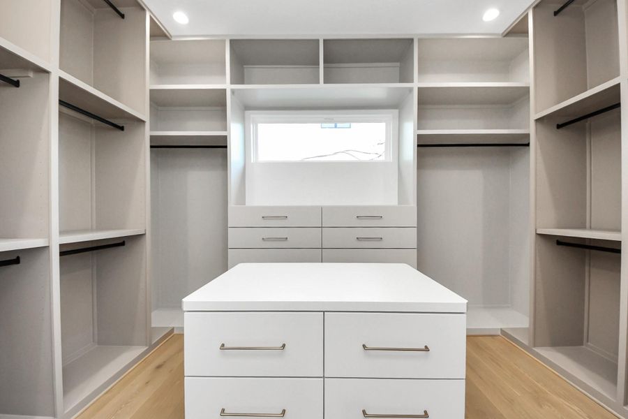 Her closet with custom shelving and island!