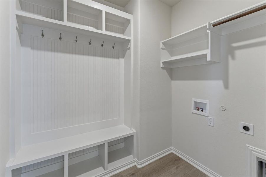 Mudroom featuring built-in white cabinetry with beadboard paneling, integrated bench seating, and overhead storage cubbies Mudroom featuring built-in white cabinetry with beadboard paneling, integrated bench seating, and overhead storage cubbies