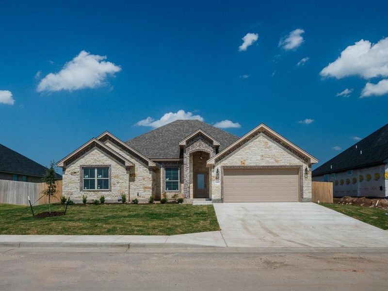 View of front of home featuring driveway, an attached garage, brick siding, and stone siding View of front of home featuring driveway, an attached garage, brick siding, and stone siding