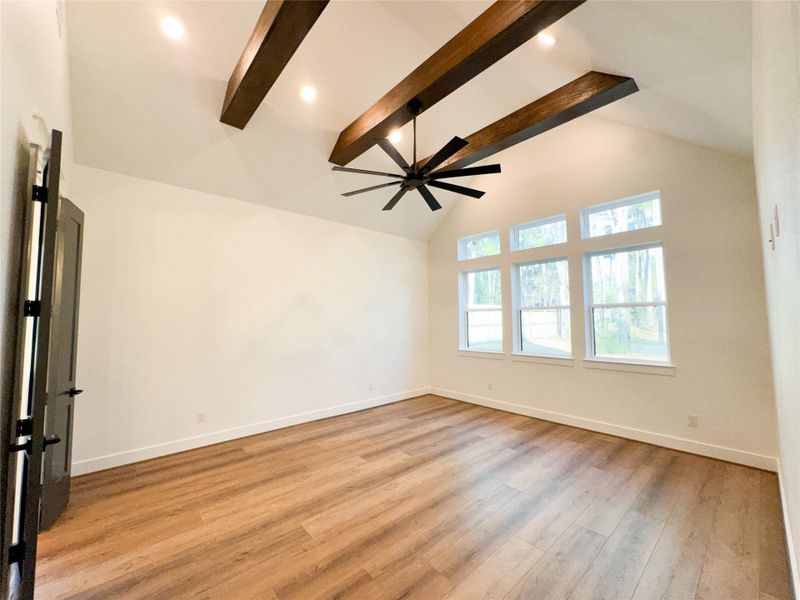 Inviting Primary Bedroom with Cathedral Ceiling, Beams and Large Windows