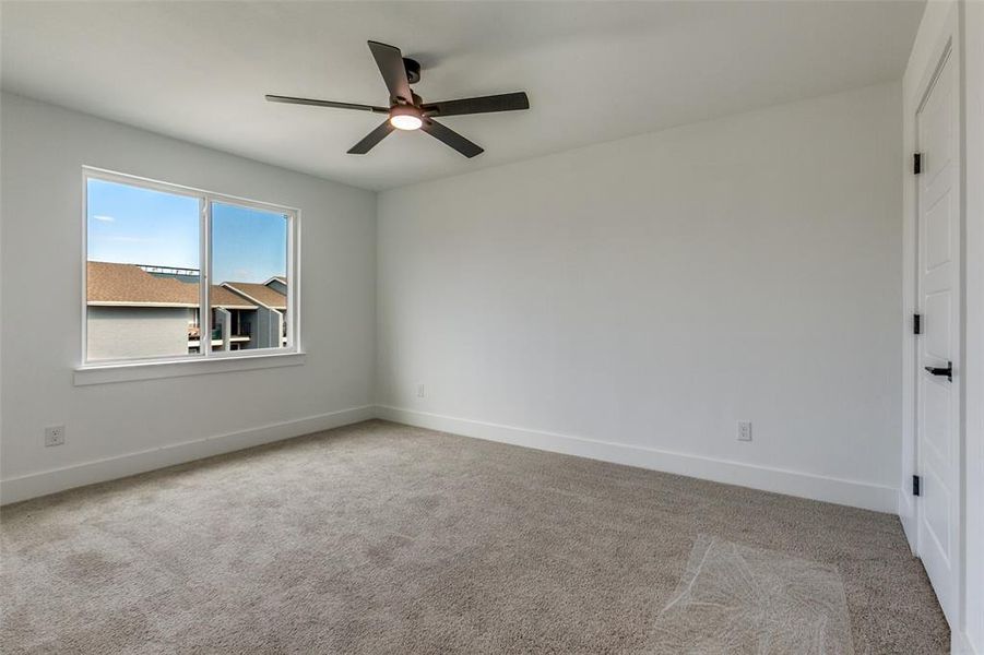 Spare room featuring light colored carpet and ceiling fan